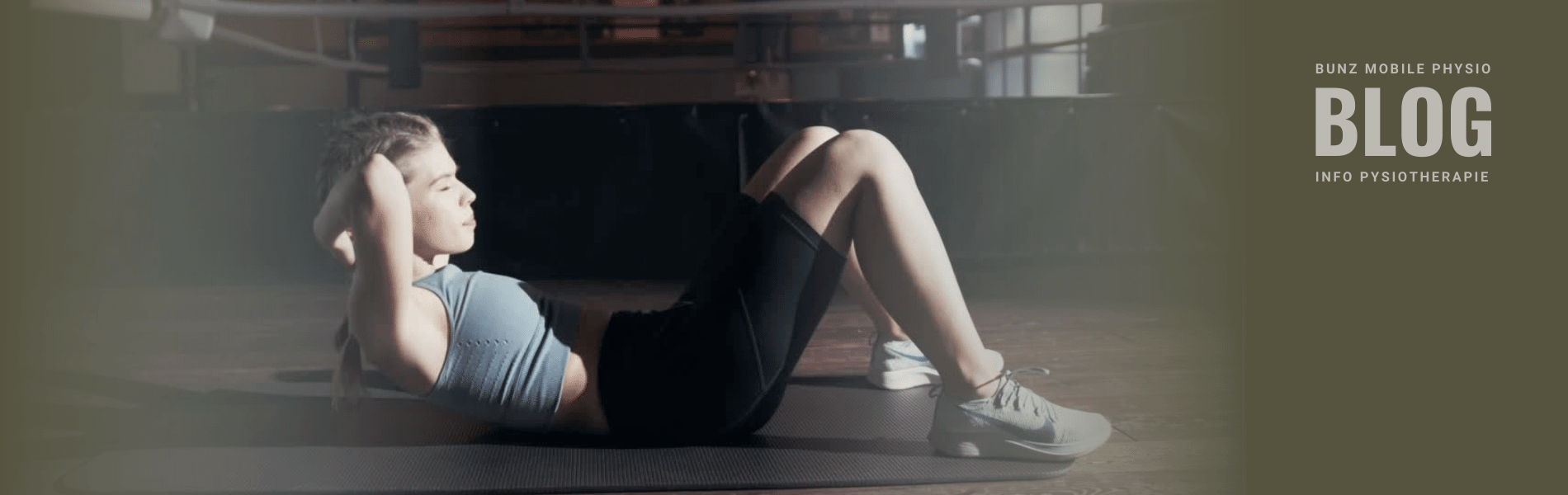 Junge Frau bleibt durch Sit-ups am Boden einer Sporthalle in Bewegung